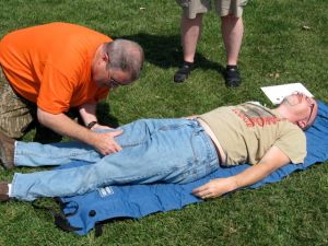 A Wilderness First Aid participant checks for a broken bone during a class simulation. 