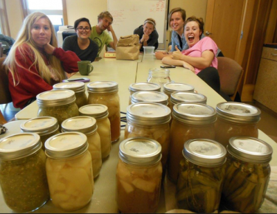 Undergraduates from Goshen College living at Merry Lea's biological field station for a semester celebrate their achievements canning produce from the Merry Lea Sustainable Farm. Practical skills related to local food are included in their curriculum. Left to right: Amber Mosely, Kokomo, Ind.; Naomi Gross, Edmonton, Alberta; David Pauls, Dallas, Oregon; Kayla Gray, Bridgton, Maine; Cecilia Lapp-Stoltzfus, Washington, D.C.; Laura Mason, Goshen, Ind. 