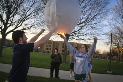 Brian Sutter (left) and Meghan Gerke (right) release a paper lantern during a Digital Eve fundraiser for Syrian Refugees. Gerke and Jeanette Shown (center) lead the Digital Eve group on campus. 
