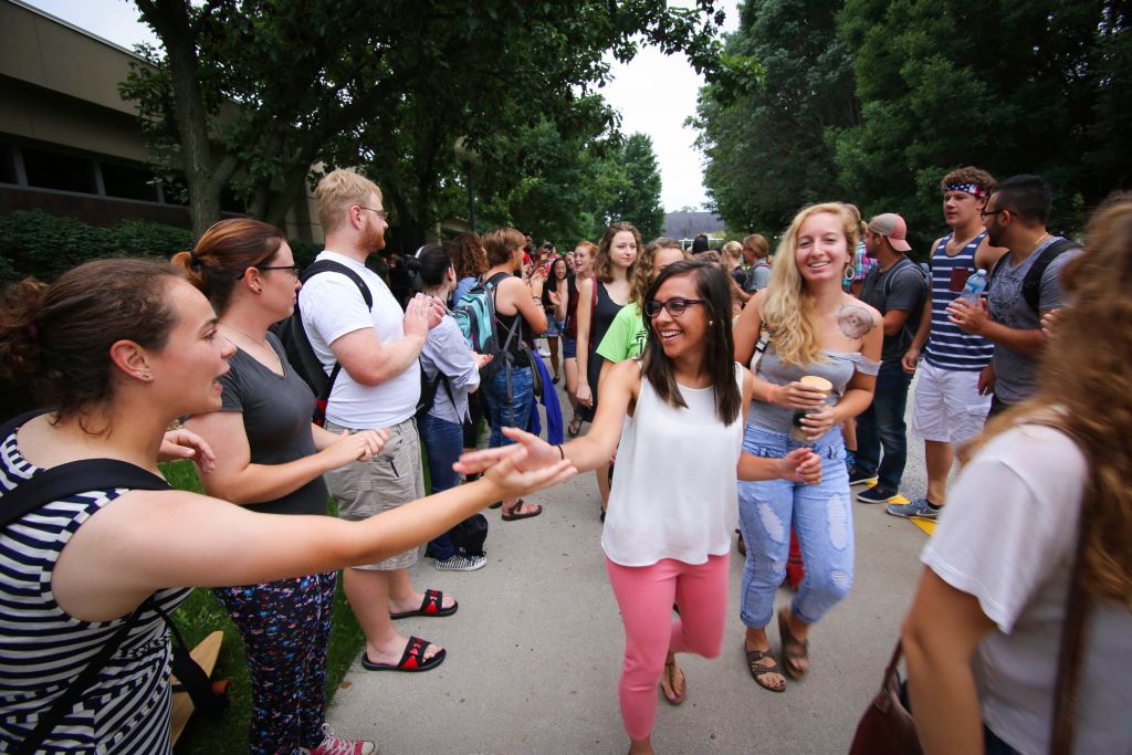 Janeth Vela (center), a senior from Goshen, high-fives Molly Zook (left), a senior from Doylestown, Ohio, during the annual applause tunnel following the opening convocation. Brynn Godshall (right), a senior from Lancaster, Pennsylvania, looks on. The applause tunnel tradition is a way to welcome new and returning students.