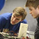 Students working among wires and circuits