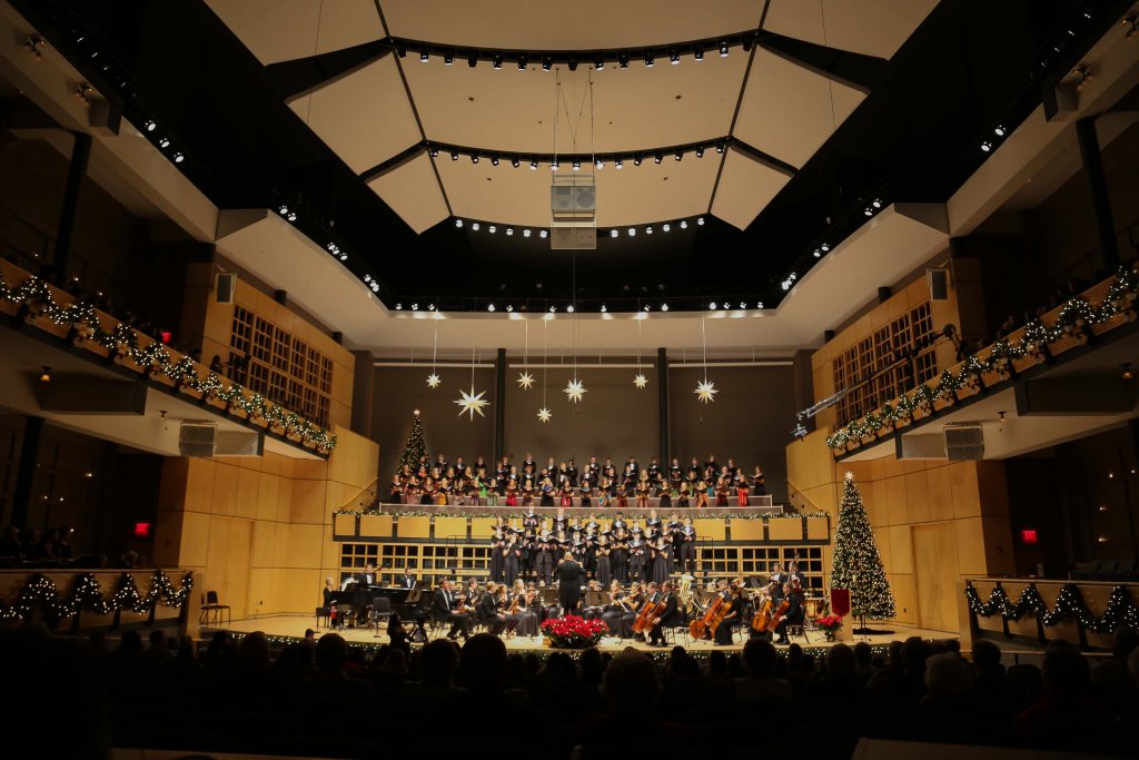 Large choir and orchestra performing on stage