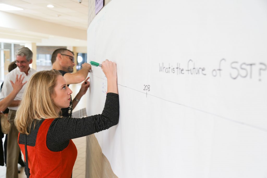 Woman writing on long sheet of paper