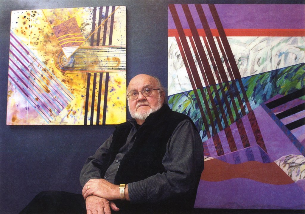 Man sitting in front of two paintings