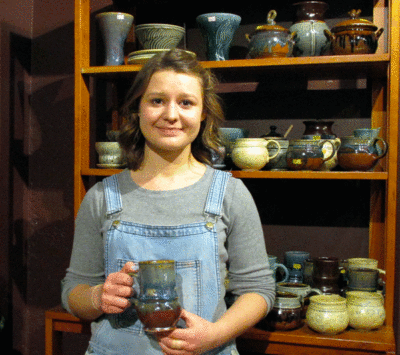 Female student holding pottery mug