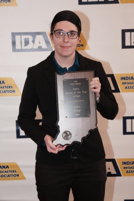 Woman wearing black holding an award