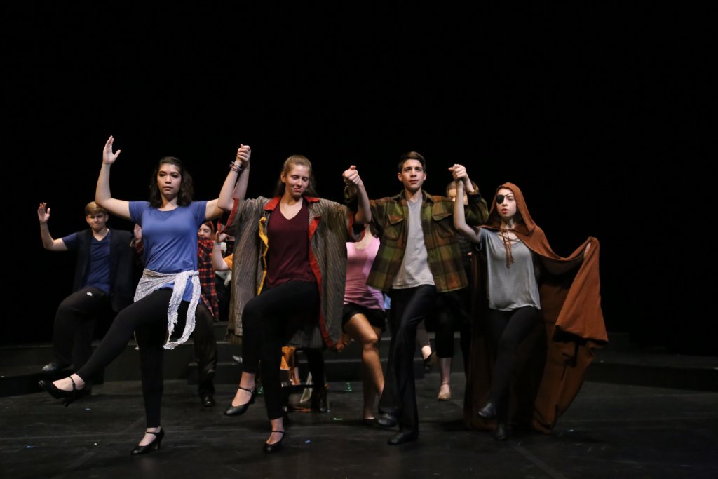 Students in costume holding hands and dancing