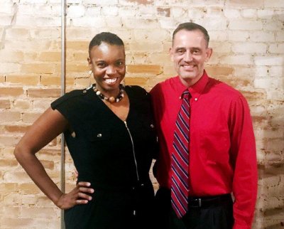 A man in red and a woman in black standing together