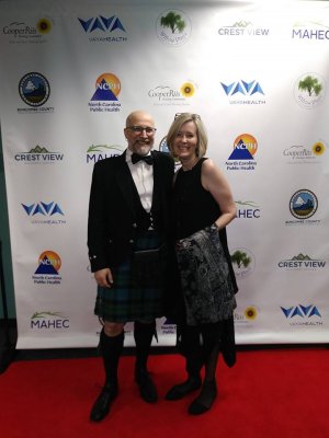 A man and a woman standing next to each other in front of a banner of logos