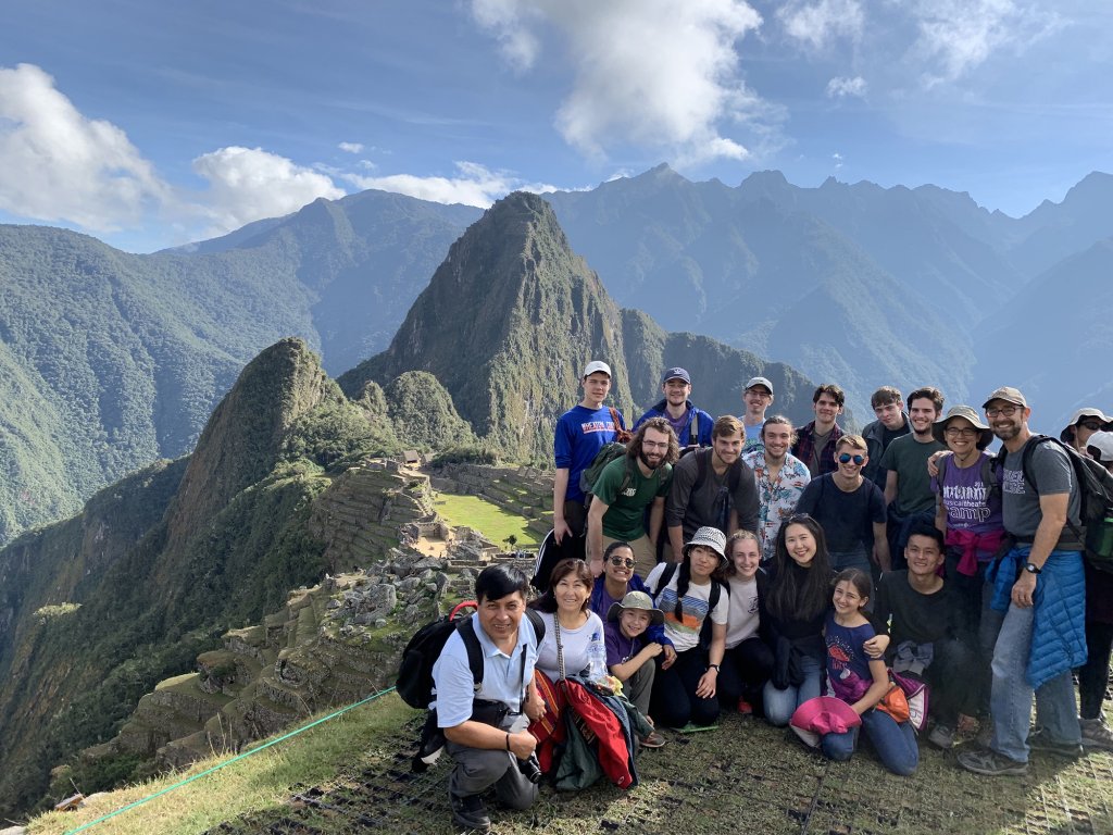 A group of people posing for a picture in front of mountains