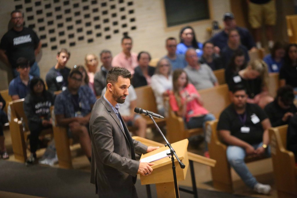 Man speaking at a podium in front of a microphone