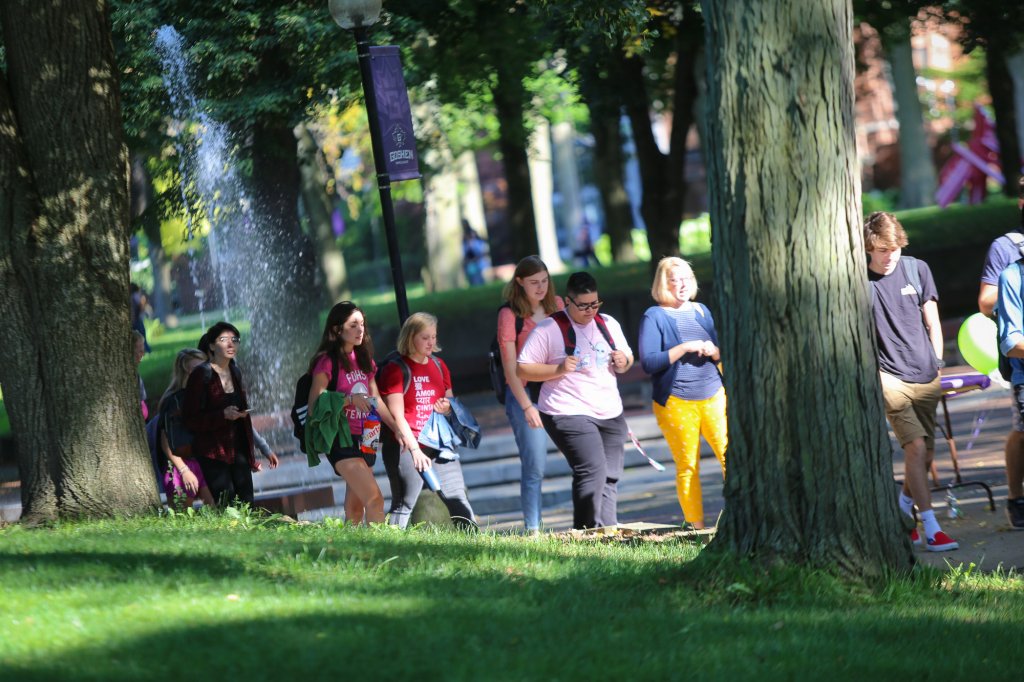 A group of people walking down the sidewalk