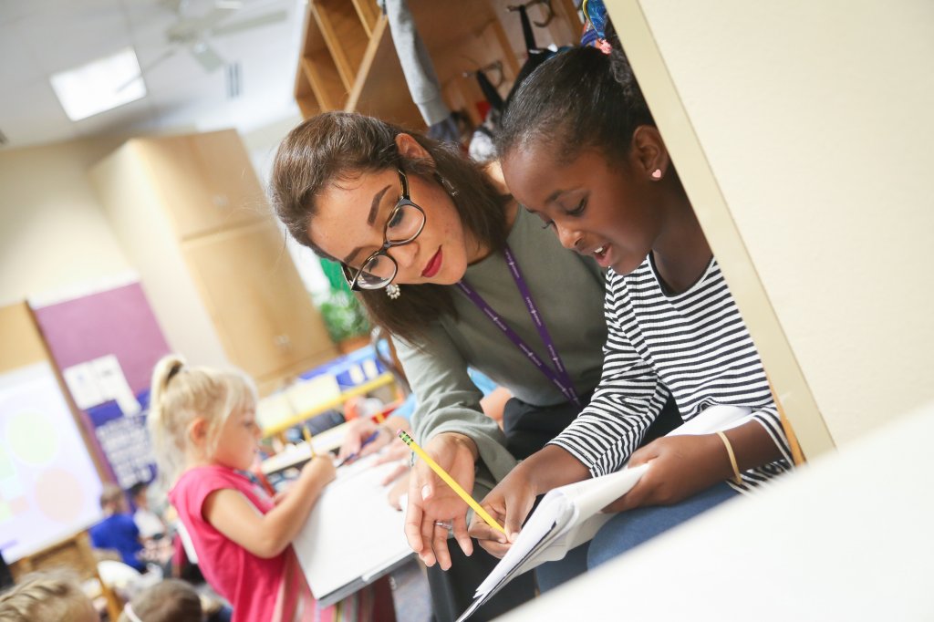 Woman helping children with schoolwork