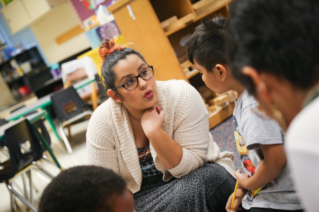 Woman talking with several young children