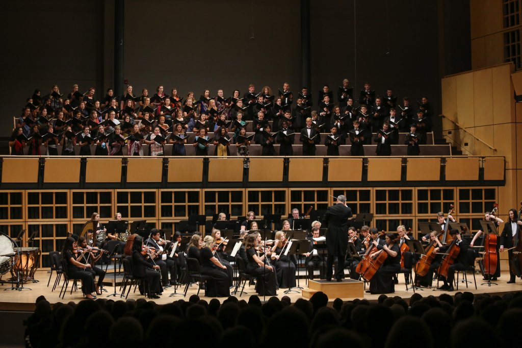 Choir singing with full orchestra on stage