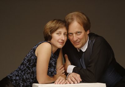 A woman and a man leaning on a table 