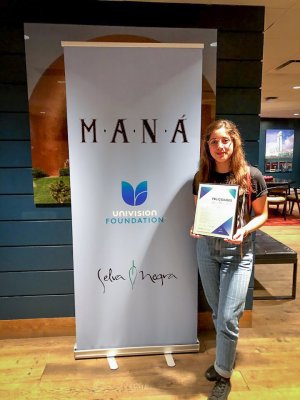 Woman posing next to MANA poster