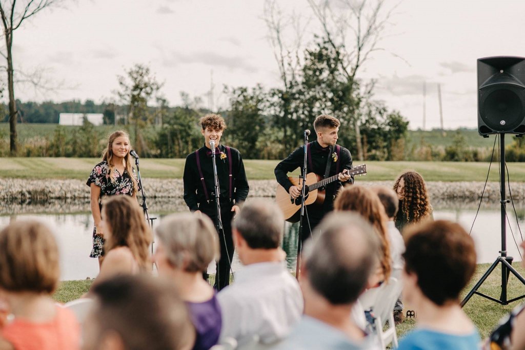 Three people performing music in front of a crowd