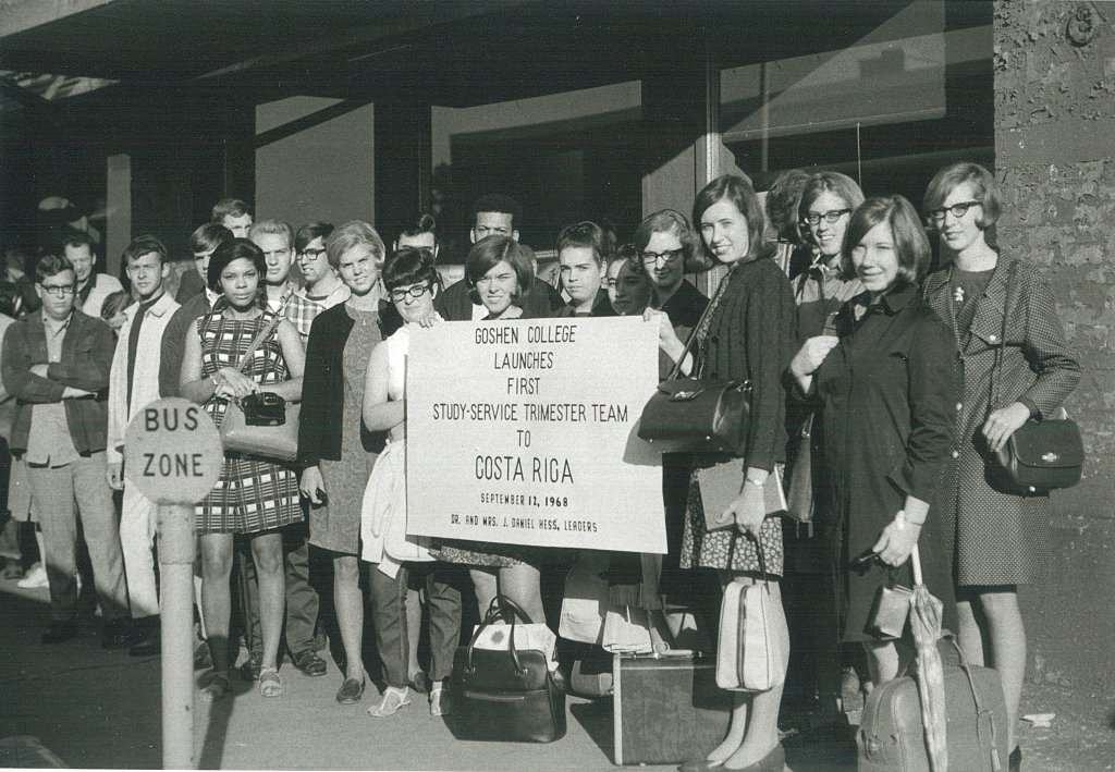 A black and white image of a group of college students in 1968, holding up a sign that reads 