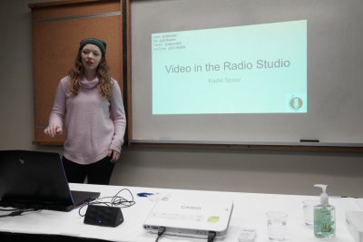 Woman giving a powerpoint presentation. "Video in the Radio Studio'