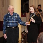 Woman receiving an award from an older man