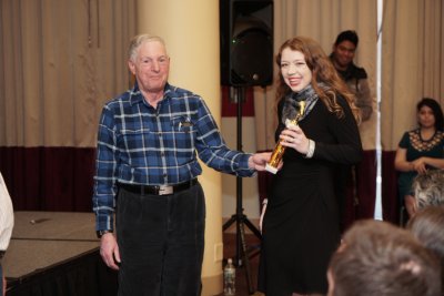 Woman receiving an award from an older man