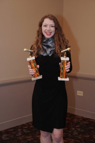 Woman holding two awards