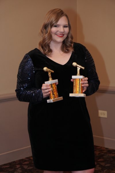 Woman holding two awards