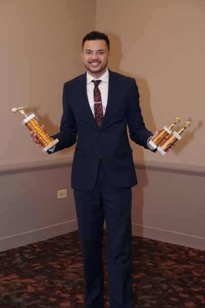 Man holding three awards