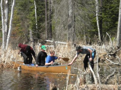 Logan Miller pulls Daniel Graber, Rebekah Steiner, and Sunday Mahaja across a submerged portion of a portage trail leading to Shell Lake.