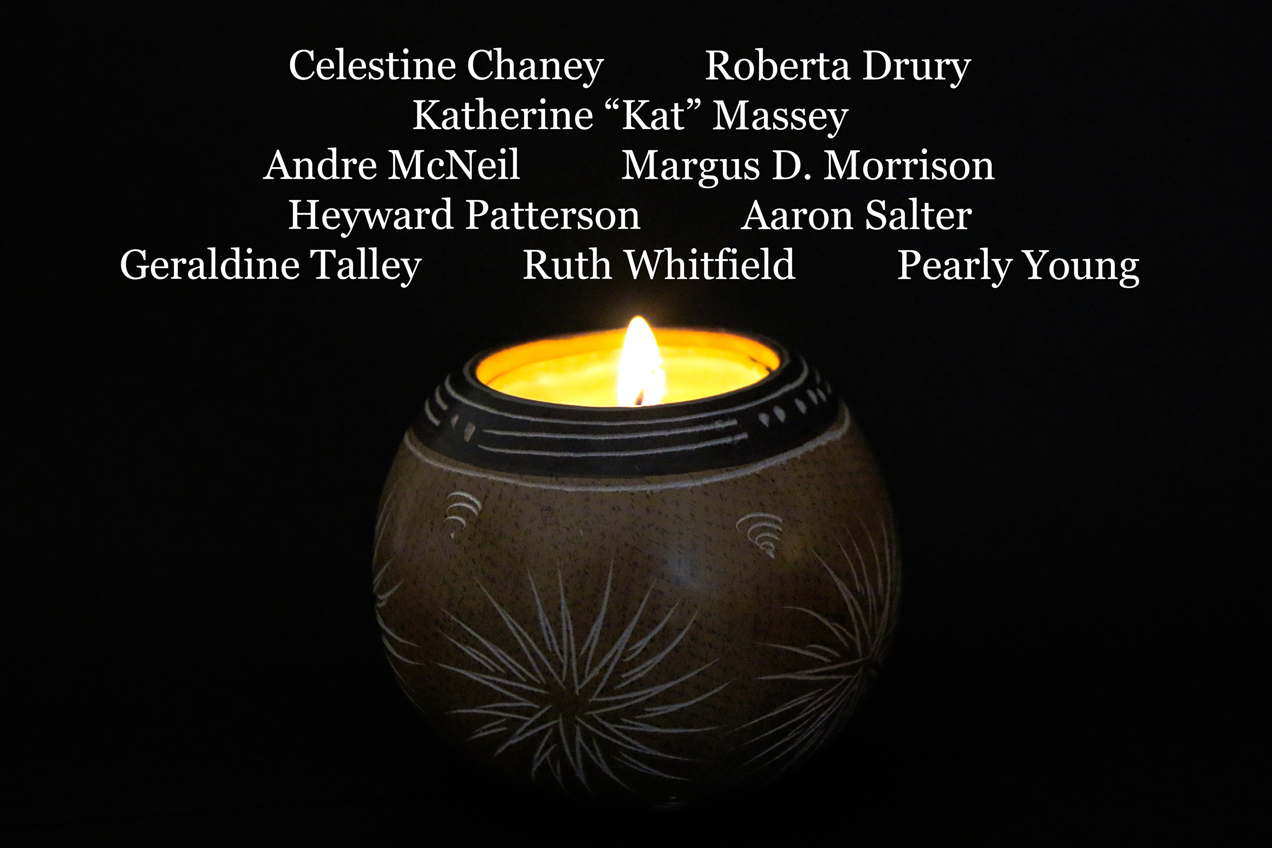 A lit candle with the names of the victims of the hate crime shooting in Buffalo, New York.